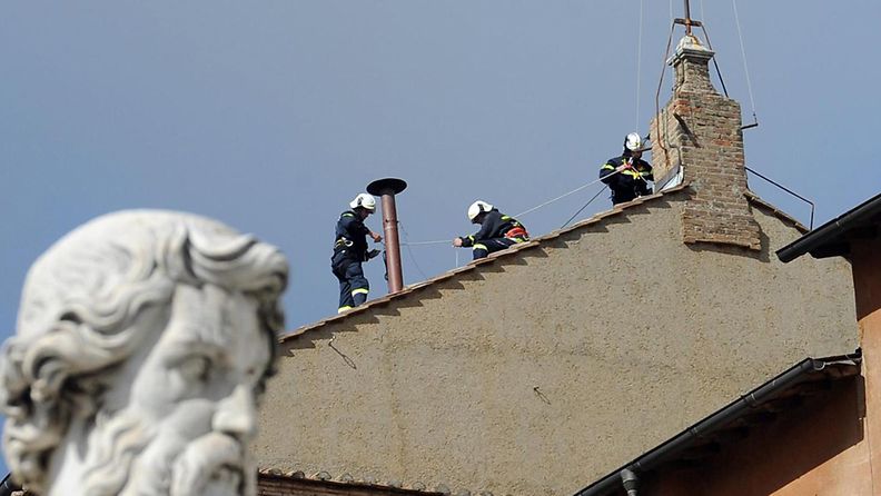 Palomiehet asensivat savupiipun Sikstuksen kappelin katolle paavin valintaa varten 9.3.2013.