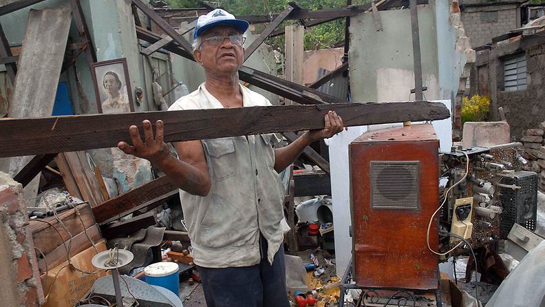 Mies kuljettaa romua hirmumyrskyn jäljiltä Santiago de Cubassa. 