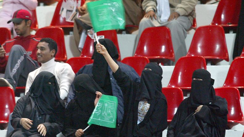 : Saudi Arabia women |wave flags in support of the Saudi soccer team during the match Saudia Arabia vs Oman in Kuwait City at the 16th Gulf Cup soccer tournament Tuesday 06 January 2004. EPA/Raed Qutena    