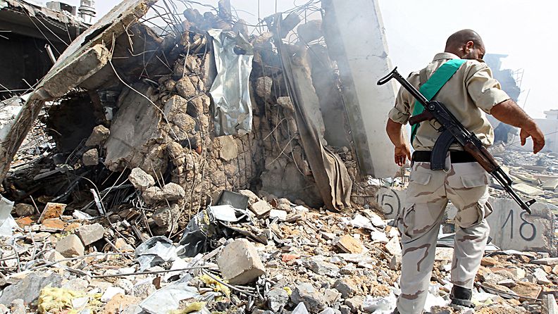 Libyalaissotilas tutkii Nato-joukkojen ilmaiskun aiheuttamia tuhoja Muammar Gaddafin palatsialueella 7.6.2011. 