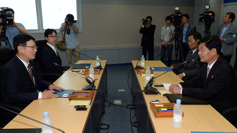 South and North Korean chief delegates shake hands prior to their working-level talks to normalize the crippled cross-border industrial complex in the North Korean border town of Kaesong on 10 July 2013. 