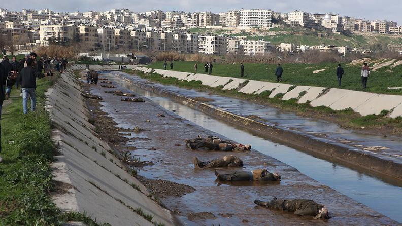 Locals gather at the banks of a small canal coming from a government-controlled suburb of Aleppo, Syria, to view dozens of bodies of people 29 January 2013. According to unconfirmed reports of eyewitnesses, most bodies had their hands tied behind their backs and had been shot in the head. Eyewitnesses, police and local residents are reported to have claimed the dead had been killed by supporters of Syrian government. EPA