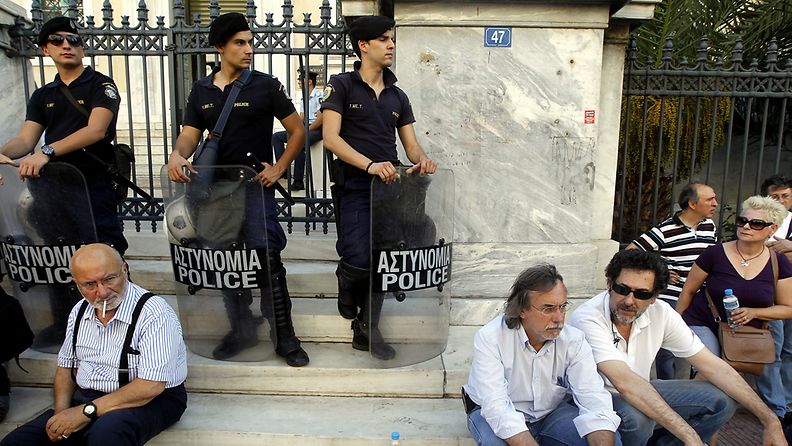 Greek public television and radio ERT employees sit on the steps of the Council of the State building in Athens on 20 June 2013