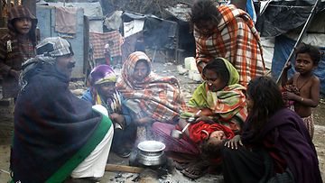Intialaisia kerääntyneenä nuotion ympärille lämmittelemään Jammun slummialueella Kashmirissa. 
