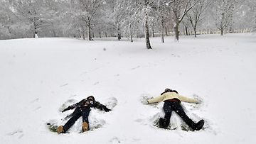 Nuoret tekevät lumienkeleitä Lontoossa 18.12.2010.