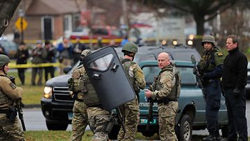 Vahvasti aseistautuneet poliisit piirittivät Newtownissa kaupungin katolista kirkkoa 16. joulukuuta 2012.