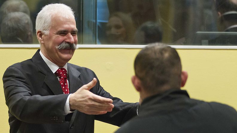 Stojan Zupljanin saapui leveästi hymyillen oikeusistuntoon Haagissa 27. maaliskuuta 2013.
