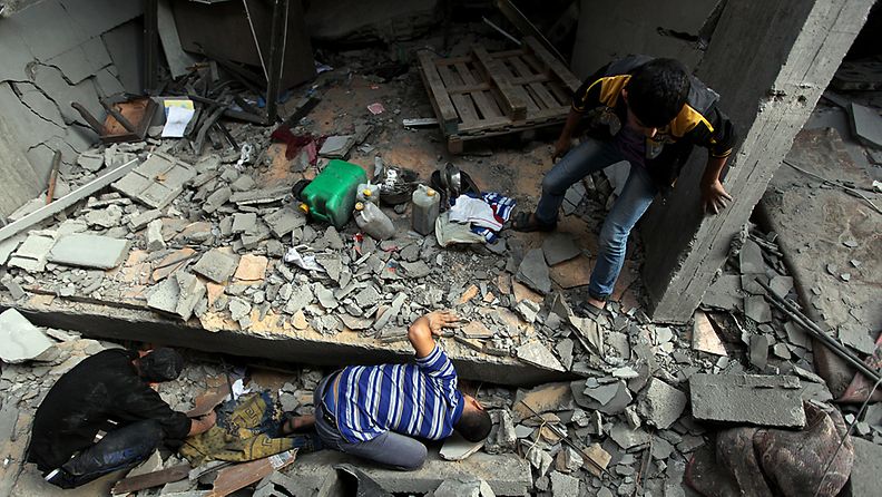 Palestiinalaiset lapset asuintalonsa raunioissa Gazassa.