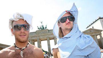 Kaksi norjalaisturistia yritti suojautua polttavalta auringonpaisteelta Berliinissä Saksassa 10.7.2010, kun lämpömittari näytti 39 astetta.