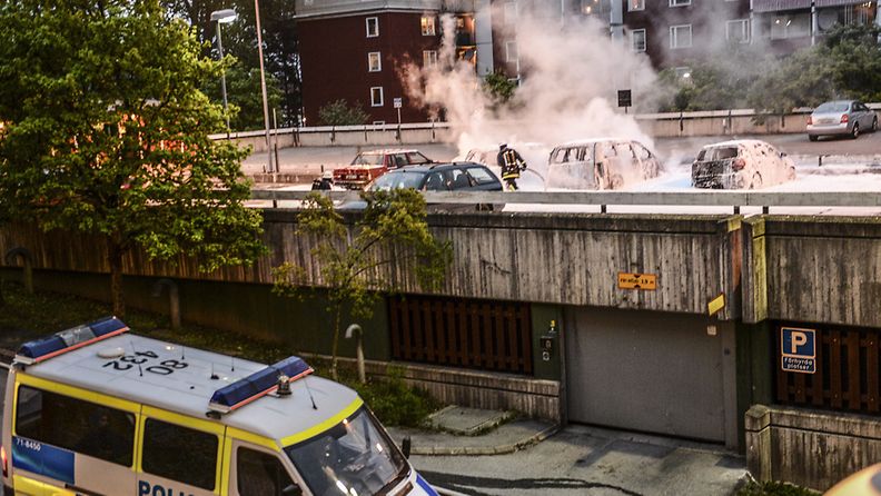 A photo made available on 21 May 2013 shows police officers and firemen beginning repair work to the damage caused by youths rioting in Husby, northern Stockholm, Sweden, 20 May 2013. The youths reportedly set fire to cars and throwing rocks at police, in what is believed to be a protest against the fatal police shooting of a machete-wielding man in the suburb last week. 