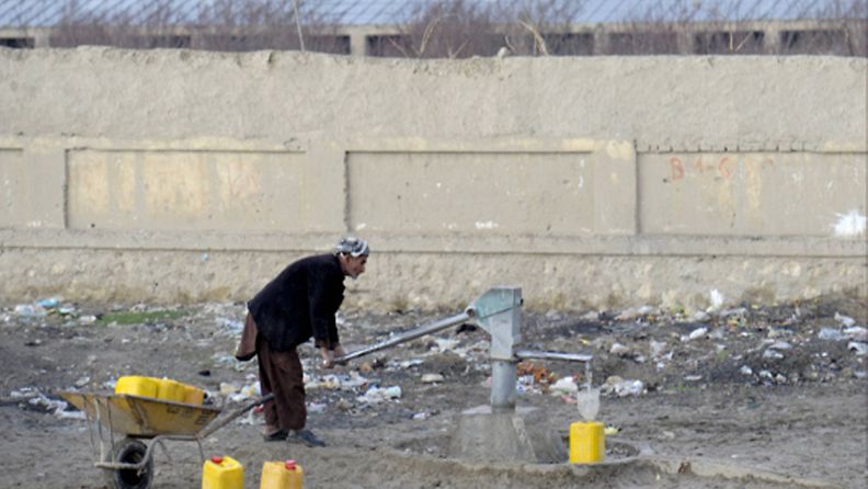 Afgaanimies pumppaa vettä yleisellä kaivolla päätien varrella Mazar-i Sharifissa Afganistanissa 30. tammikuuta 2013. Mm. suomalaisten ISAF-kriisinhallintajoukkojen tukikohta Camp Northern Lights sijaitsee Mazar-i Sharifissa.