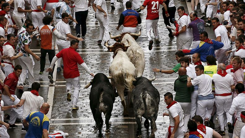 Härkäjuoksijat pakenivat härkiä Pamplonan ensimmäisessä härkäjuoksussa 7. heinäkuuta.