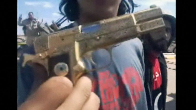 Ruudunkaappauskuva kännykkävideosta, jossa esitellään Muammar Gaddafin kultaista asetta. 