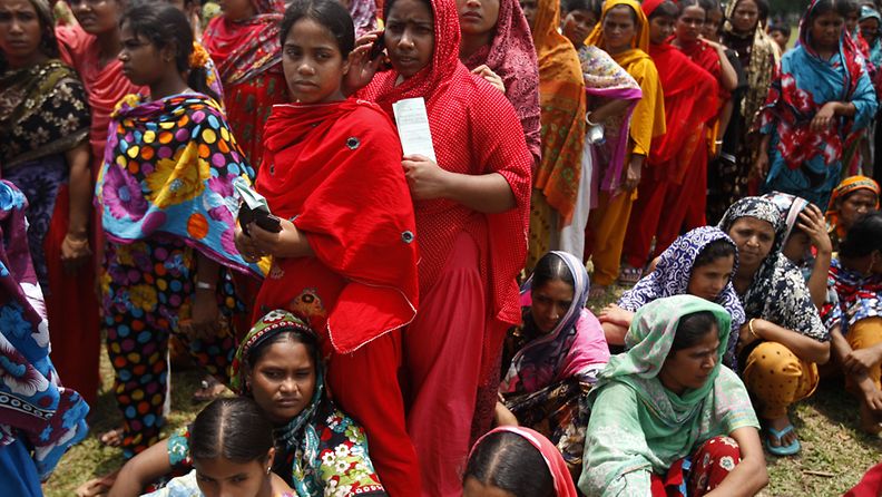 Tekstiilitehtaan romahduksesta selvinneet työntekijät jonottivat palkkojaan ja korvauksia Bangladeshissa.