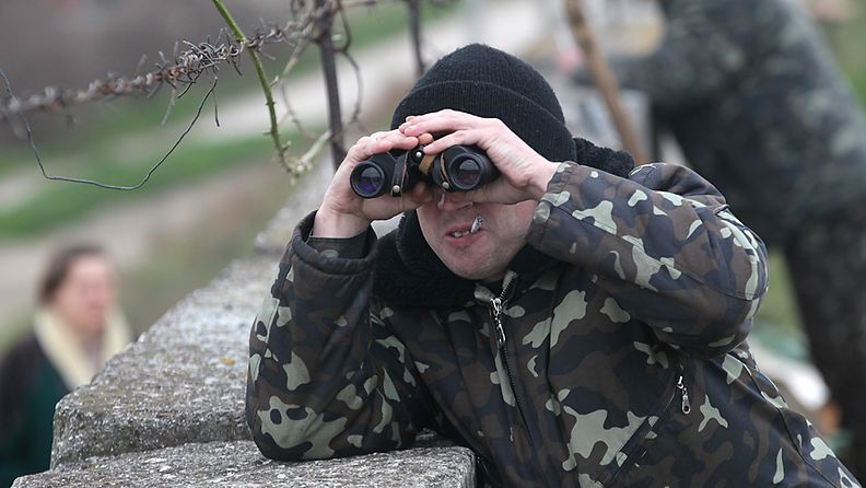 Ukrainalainen sotilas kiikaroi Ukrainalle kuuluvassa Belbekin lentotukikohdassa Sevastopolin ulkopuolella.