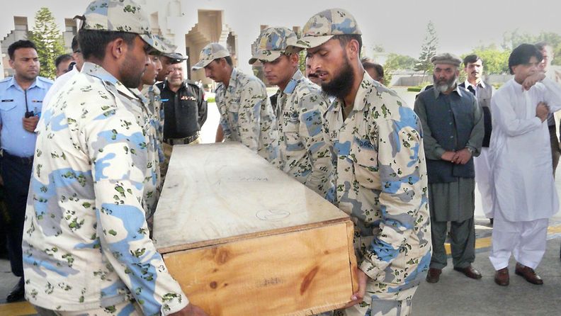 Sotilaat kantoivat surmattujen kiipeilijöiden puuarkkuja kuljetuskoneeseen Pakistanissa 23. kesäkuuta 2013. 