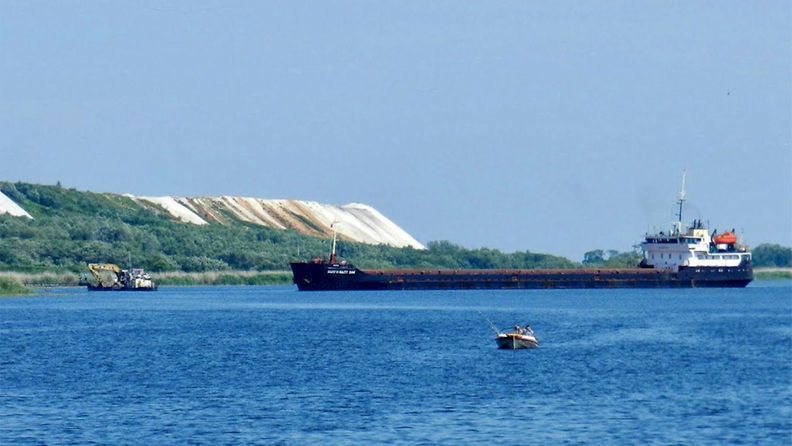 Oder-joella kulkeva laiva on tuomassa Afrikasta apatiittia Policen fosforilannoitetehtaalle. Taustalla näkyy kipsivuori, johon tehtaan jätekipsi kasataan.
