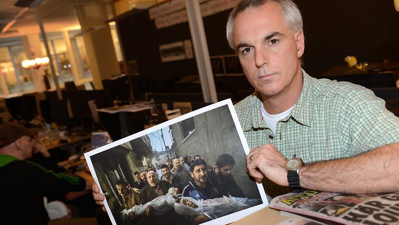 Paul Hansen of Sweden, a photographer working for the Swedish daily Dagens Nyheter holds his winning picture as he poses for photographs at the Dagens Nyheter office in Stockholm, Sweden, 15 February 2013. Hansen has won the World Press Photo of the Year 2012 with this picture of a group of men carrying the bodies of two dead children through a street in Gaza City taken on 20 November 2012
