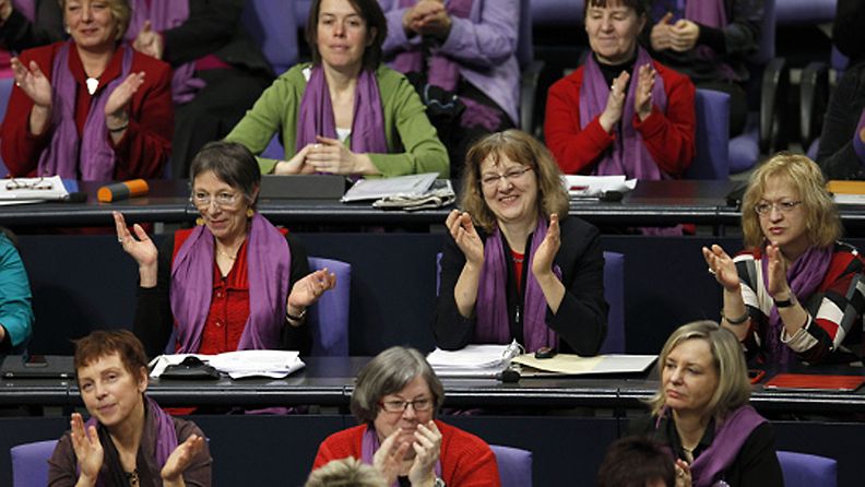 Members of the Left Party faction applaud during a meeting of the German Federal Parliament Bundestag in Berlin, Germany, Thursday, March 8, 2012. The Left Party sent only women wearing a purple scarves to the debate about women's equality in Germany on International Women's Day. (AP Photo/Michael Sohn)  Lehtikuva