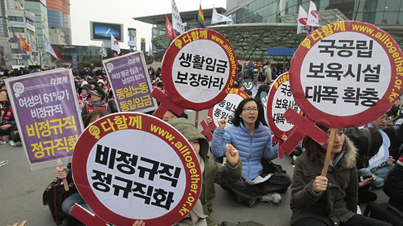 South Korean female workers shout slogans during a rally to mark International Women's Day in Seoul, South Korea, Thursday, March 8, 2012. The letters read "Preserve a living wage and hire more temporary employees." (AP Photo