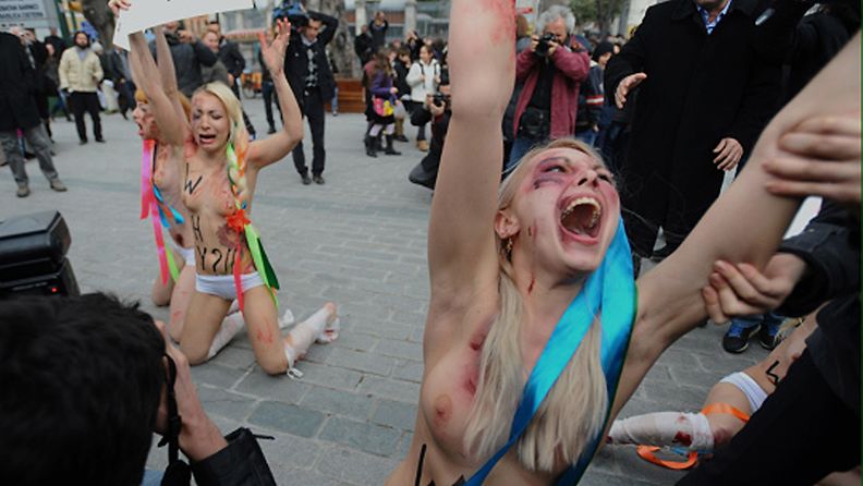  Police detain one of the Ukrainian women's rights activists as they stage a topless demonstration to protest domestic violence against women in Turkey, in Istanbul, Thursday, March 8, 2012, just hours after a man shot dead a female relative. Four members of the Femen group, wearing makeup to represent injuries, chanted slogans and displayed banners like "stolen lives" in the one-minute protest in to mark International Women's Day. (AP Photo)  