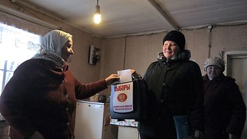Venäläinen nainen äänestää kotonaan presidentinvaaleissa.