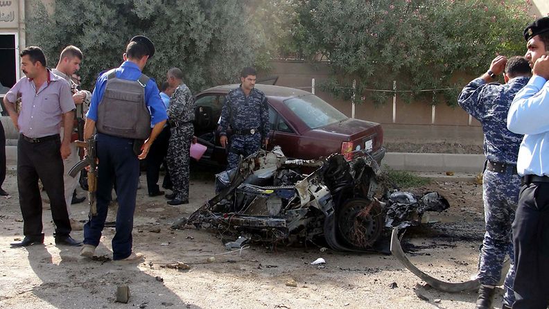 Irakilaiset poliisit tutkivat autopommin jälkiä Kirkukissa. 