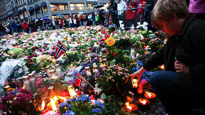 Kynttilät, kukat ja liput koristavat Oslon katuja pommi-iskussa ja ampumisessa surmansa saaneiden muistoksi. Kuva: EPA