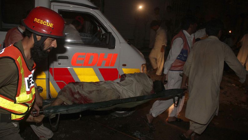 Pelastustyöntekijät kuljettavat haavoittuneita hoitoon Peshawarin pommi-iskujen jälkeen 12.6.2011. EPA