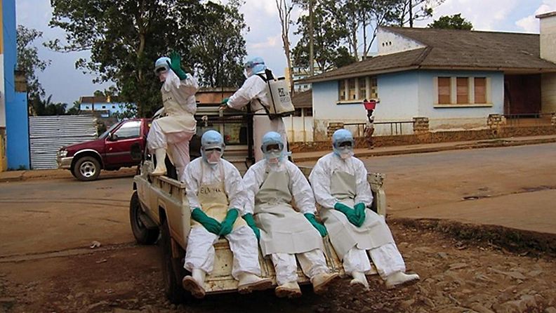 Suojapukuihin pukeutuneet terveysviranomaiset matkalla hakemaan kuumetautiin kuollutta miestä Angolassa vuonna 2005.