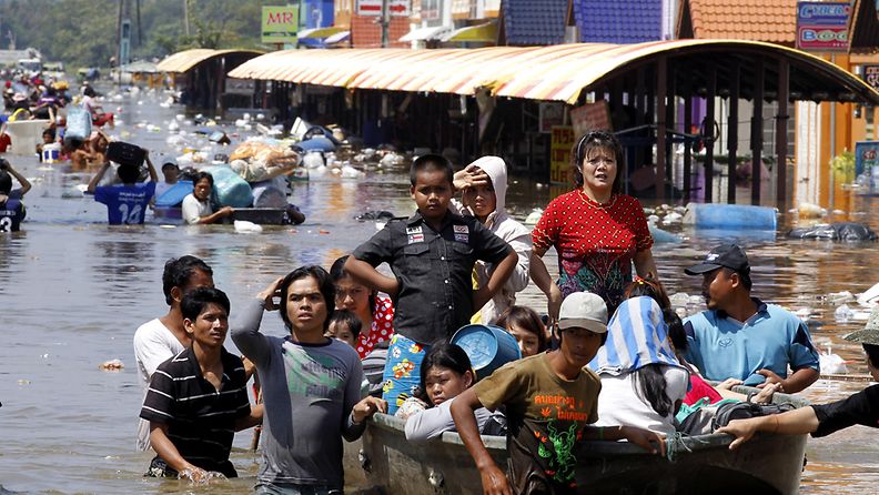 Thai residents with their belongings wade through floodwaters as they leave the area at Pinehurst Golf Club, Pathum Thani province on the outskirts of Bangkok, Thailand, 19 October 2011.
