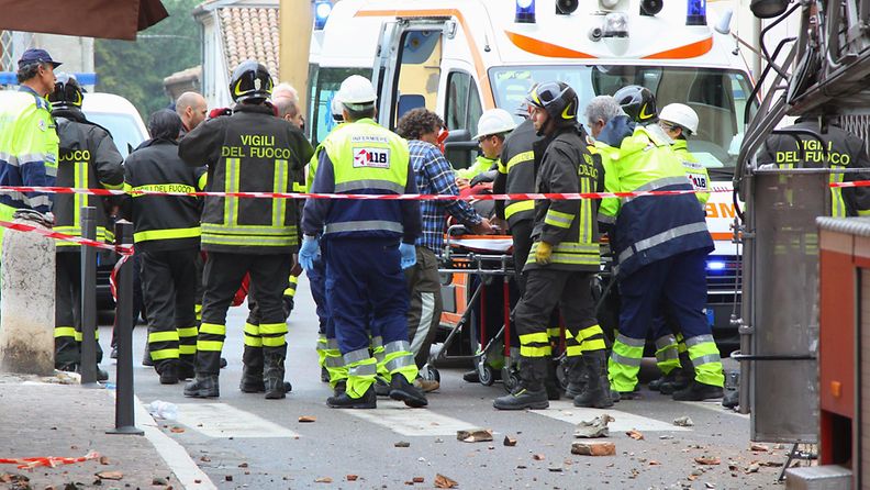 Loukkaantunutta palomiestä viedään ambulanssiin Finale Emiliassa Modenassa.