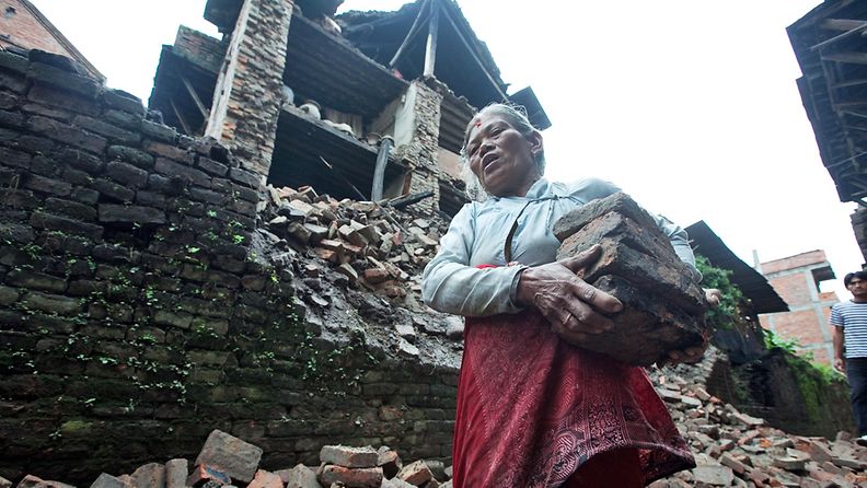 Nepalilaisnainen maanjäristyksen raunioittaman kotinsa ulkopuolella Katmandun lähellä.
