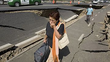 Nainen kävelee pahoin vaurioituneessa Santiagossa Chilessä 27.2.2010. Kuva: Epa