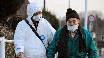 Iäkästä miestä saatetaan turvaan Fukushiman maakunnassa, jossa pelätään ydinvoimalaonnettomuuden seurauksia. Kuva :EPA