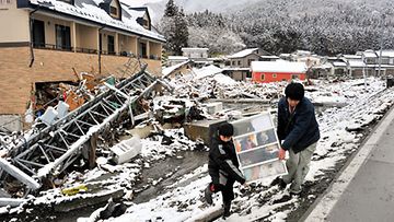 Talven ja lumen palatessa Pohjois-Japaniin, perheet hakevat talvivaatteitaan raunioista. 16.3.2011 Kuva:EPA