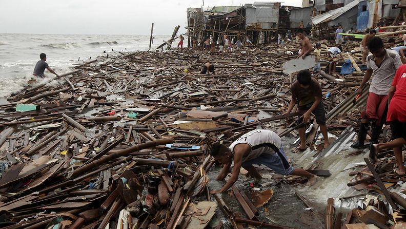 Paikalliset keräävät mereen huuhtoutuneita laudanpätkiä Filippiineillä Nefat-taifuunin jälkeen. Kuva: EPA