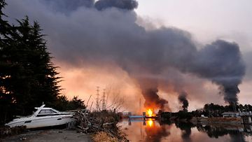 Palava petroolirikastamo syöksee savua Miyagin maakunnassa 13.3.2011. Kuva: EPA