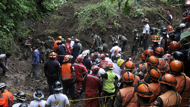 Pelastustyöntekijät etsivät maanvyöryn alle jääneitä ihmisiä Guatemala Cityssa eilen.