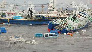 Autot ja laivat huuhtoutuivat mereen Fukushiman maakunnassa. Kuva otettu 12.3.2011. (EPA)