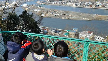 Pikkupojat katselevat tsunamin tuhoja näköalapaikalla Miyagin maakunnassa 13.3.2011. Kuva: EPA