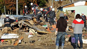 Pelastustyöntekijät tutkivat tsunamin aiheuttamia tuhoja Sendaissa Japanissa 12.3.2011. Kuva: EPA