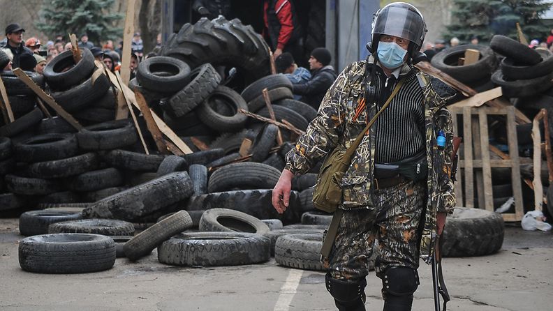 Aseistettuja miehiä vallatun poliisiaseman edessä Slovjanskissa Ukrainassa 12.4.2014.