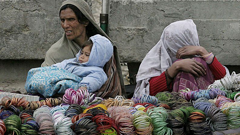 Afganistanilaisnainen pitää lasta sylissään kadulla Kabulissa Afganistanissa 7.3.2008.