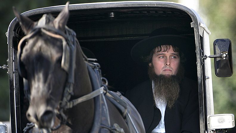 Amish-uskonlahkoon kuuluva mies ajaa hevoskärryä. 