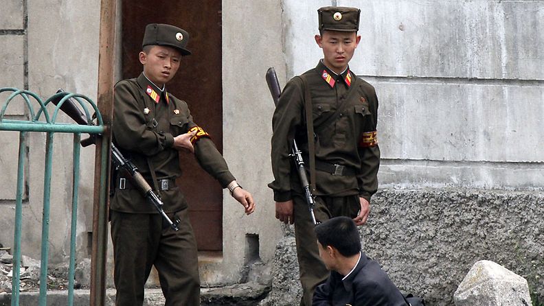 Rajavartijat tarkastavat miehen henkilöllisyyttä Pohjois-Korean rajalla 20.5.2011.