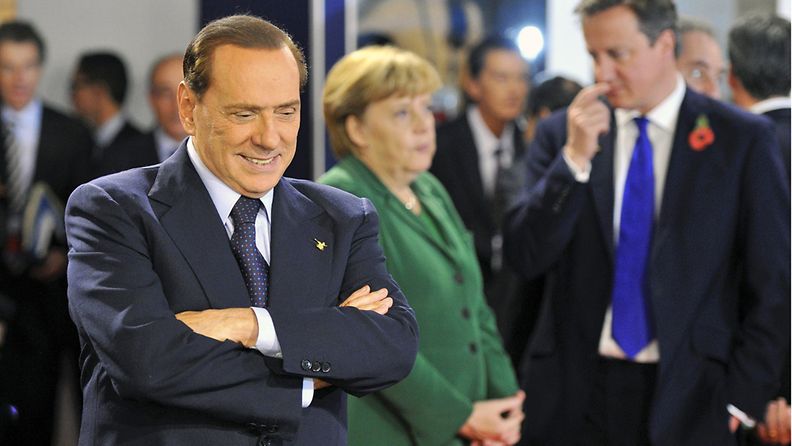 Italian pääministeri Silvio Berlusconi, taustalla Saksan liittokansleri Angela Merkel. Kuva: EPA