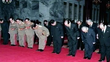 Korkea-arvoisia pohjoiskorealaisia virkamiehiä osoittamassa kunnioitustaan Kim Jong-Ilin ruumiin äärellä. 