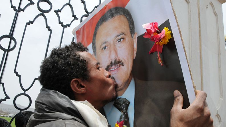 Salehin kannattaja suutelee presidentin kuvaa tämän puolesta järjestetyssä mielenosoituksessa 24. kesäkuuta 2011.