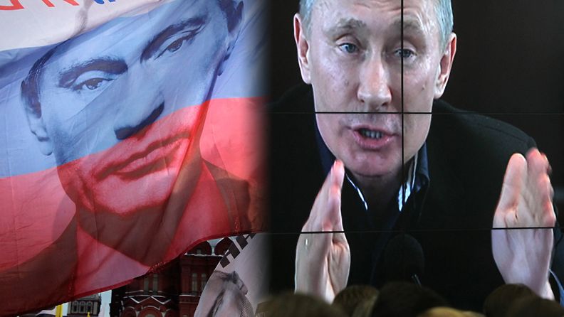 Putinin kasvot tervehtivät kannattajia niin lipuissa kuin videonäytöllä.
